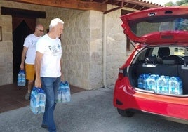 Dos vecinos de Fresnedo recogían agua embotellada de la Casa del Concejo cuando no podían consumir la del grifo.