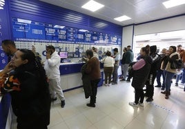 Clientes en una administración de loterías. Imagen de archivo.